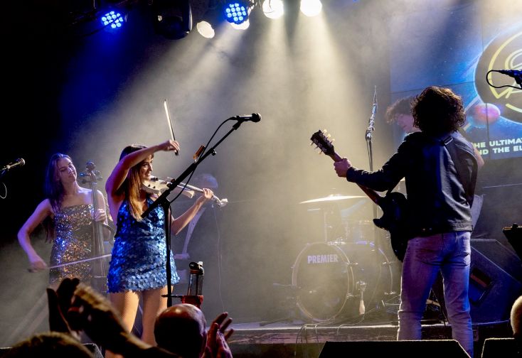 A Guitarist and violist play on stage